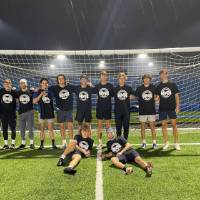 Students wearing championship shirts from a men's soccer tournament